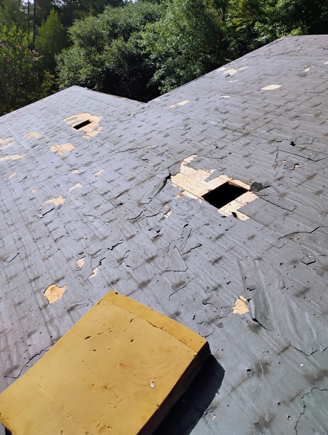 Storm-damaged roof before repair